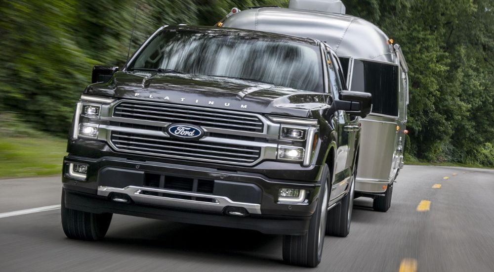 Head-on view of a black 2025 Ford F-150 Platinum towing an Airstream trailer.