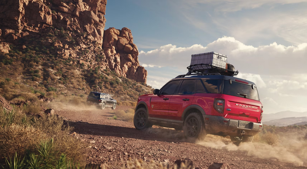 Rear of a red 2025 Ford Bronco Sport driving through a desert.