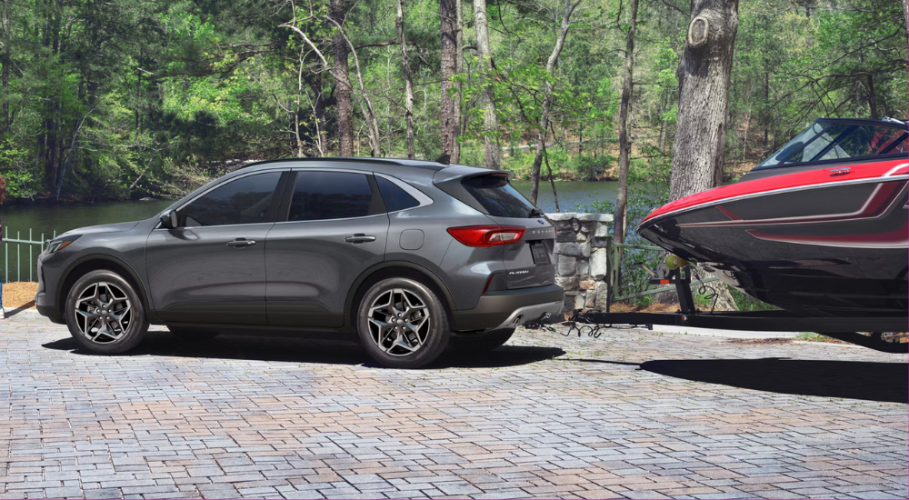 Silver 2025 Ford Escape towing a boat