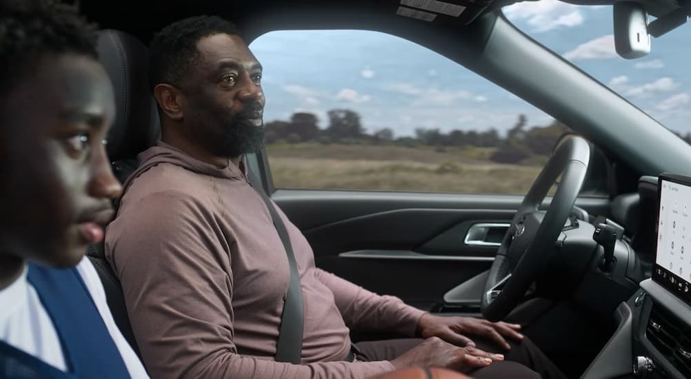 Two people driving in a 2026 Ford Explorer for sale in Baldwin.