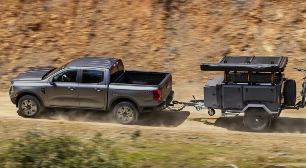 A silver 2026 Ford Ranger towing a trailer.