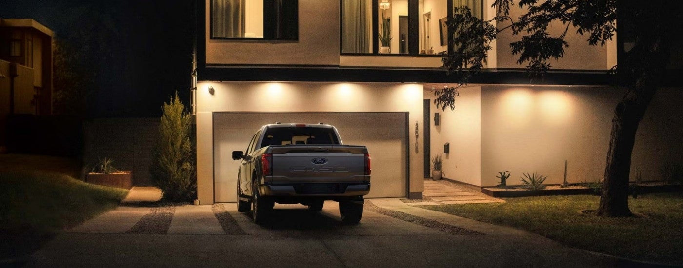Rear of a silver 2026 Ford F-150 parked on a driveway.