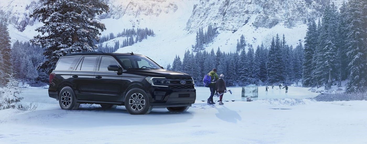 Black 2023 Ford Expedition XL STX parked near a snowy forest.